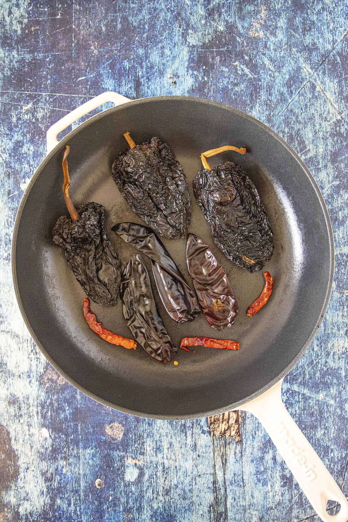 Toasting dried chilies in a pan to make Red Enchilada Sauce