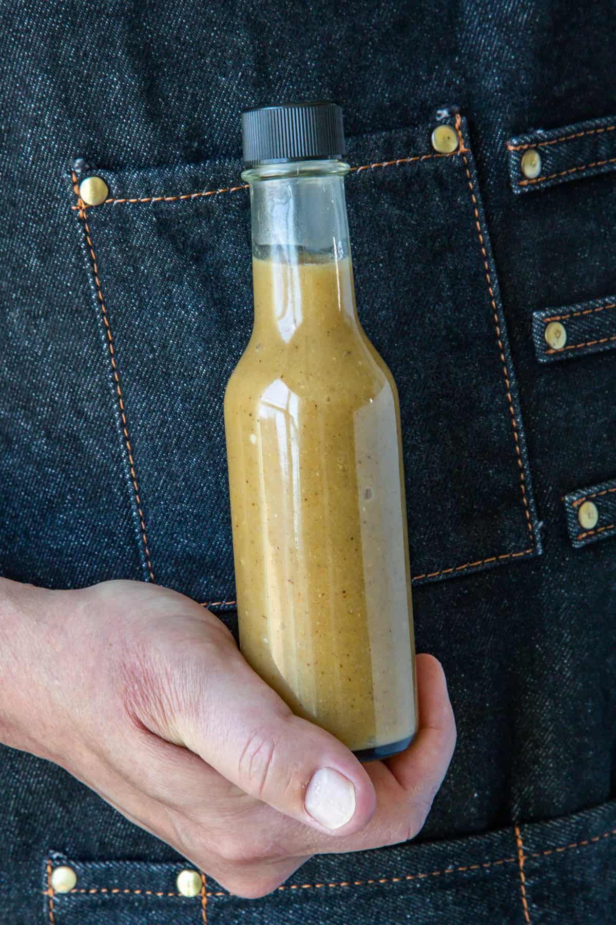 Mike holding a bottle of spicy Caribbean-Style Mango-Habanero Hot Sauce