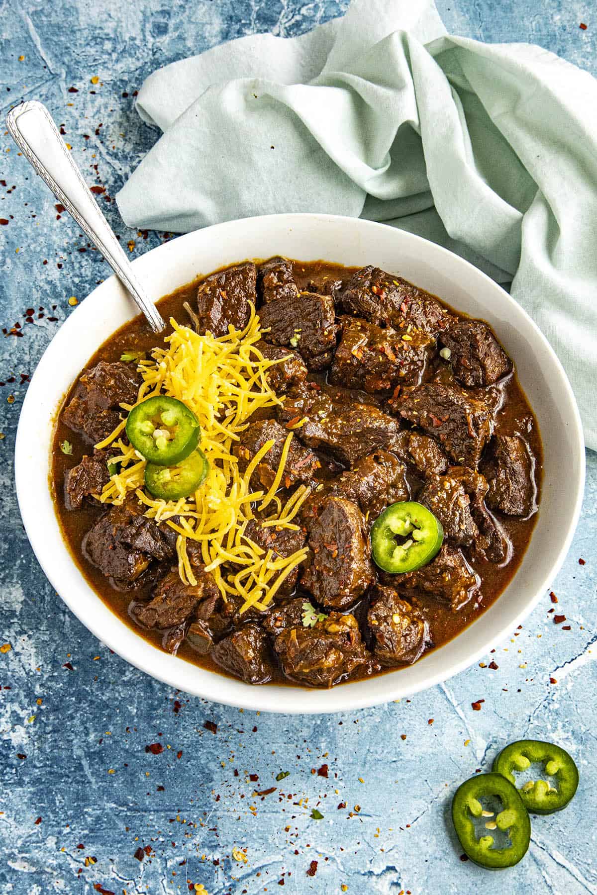 A bowl of Texas Chili with cilantro and chilies