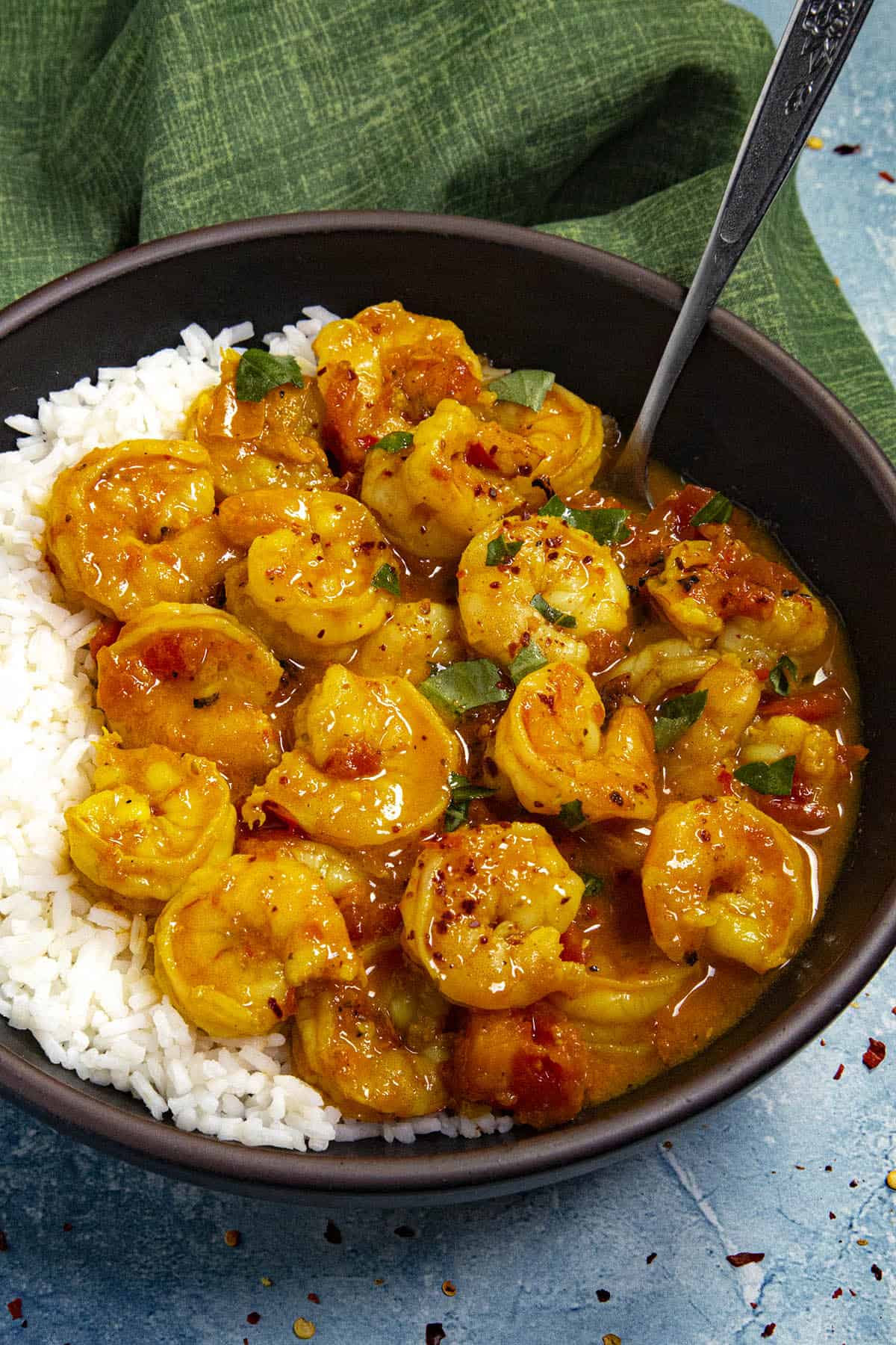 Thai Shrimp Curry in a bowl with torn basil garnish and Jasmin rice