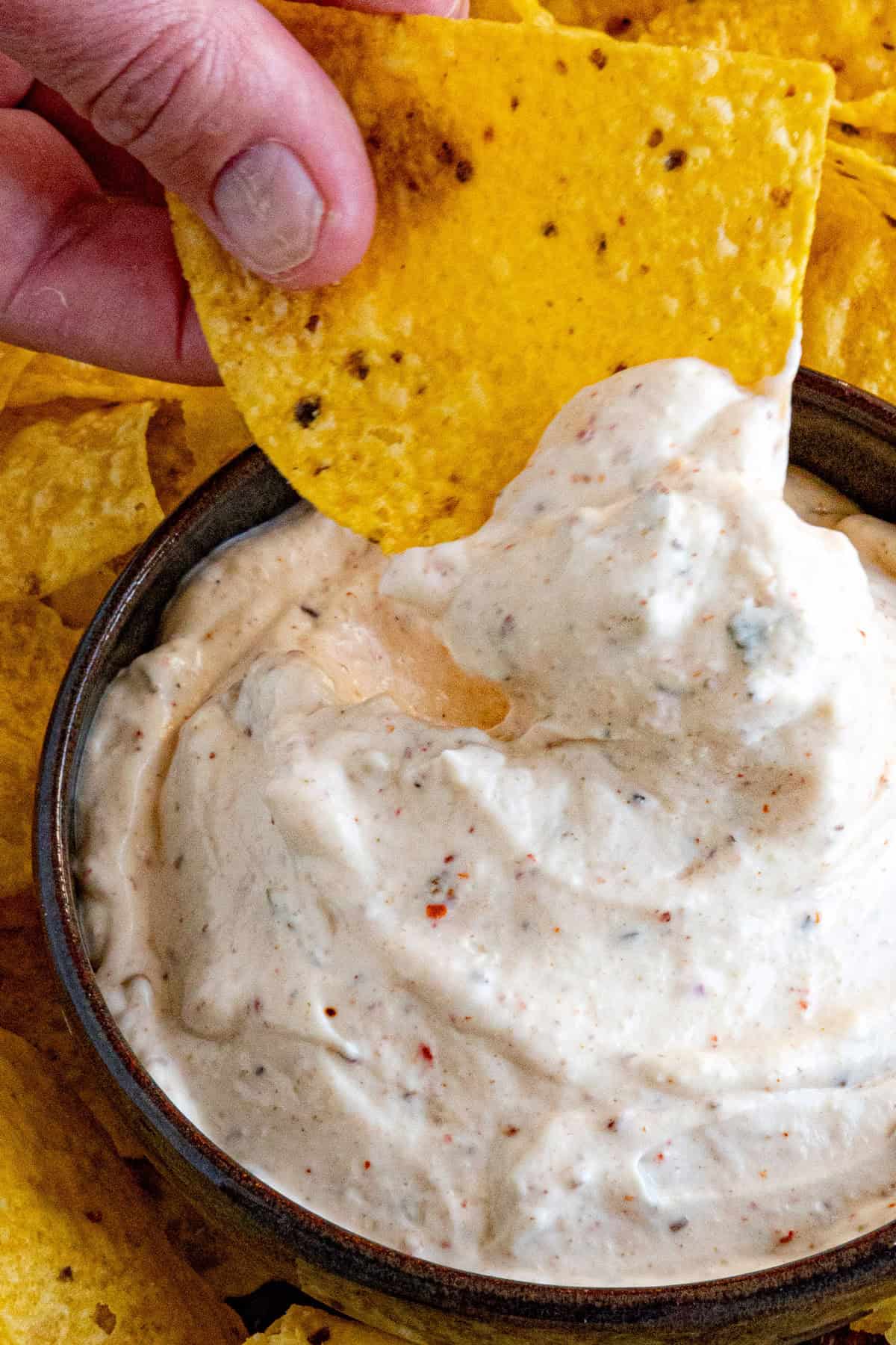 Dipping a chip into a bowl of Mexican White Sauce (Salsa Blanca)