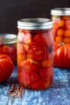A large jar of Pickled Tomatoes on a table