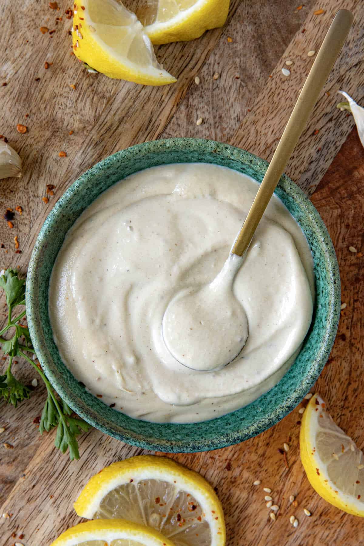A spoon settling into a bowl of Creamy Tahini Sauce