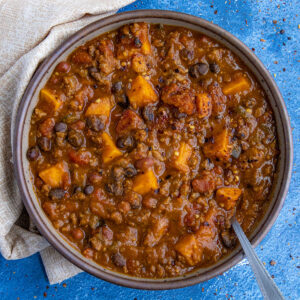 A bowl of hearty, chunky pumpkin chili, loaded with lots of pumpkin, beans, and fire roasted tomatoes