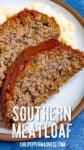 Two thick slices of southern meatloaf on a plate, glazed with tangy tomato sauce, served over creamy mashed potatoes