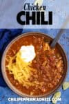 Chicken Chili in a bowl, topped with shredded cheddar cheese and sour cream