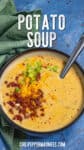Loaded baked potato soup served in a bowl, garnished with crumbled bacon, shredded cheddar cheese, and chives