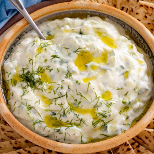 Homemade Tzatziki Sauce served on a plate with slices of pita bread